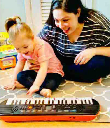 toddler learning to play the piano with happy piano